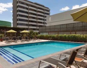 stunning outdoor pool with sunbeds and umbrellas at Hilton Colon Quito.