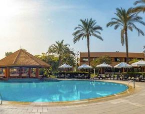 stunning outdoor pool with sunbeds and umbrellas at Hilton Cairo Heliopolis.