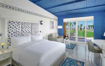 spacious king suite with desk, chair, couch, and outdoor terrace at Hilton Hurghada Plaza.