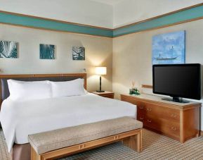 Queen room with chairs, desk and sliding doors at the Hilton Yaounde.