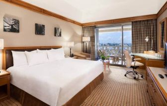 King suite with 1 king bed, desk,chair, tv and city view at the Hilton Yaounde.