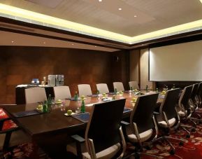 Sleek boardroom with large projection screen, seating for up to 12-15 people.