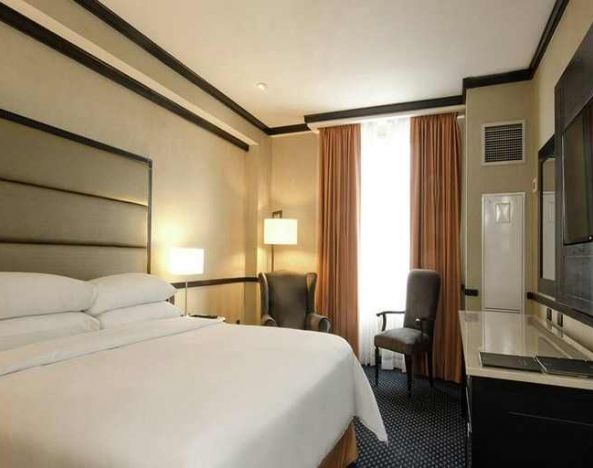 comfortable delux king room with TV and couches at Hilton Princess San Pedro Sula.