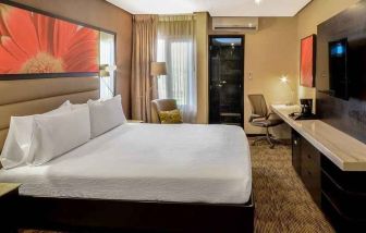 delux king room with TV, desk, and chair at Hilton Garden Inn Guatemala City.