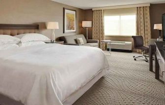 Spacious king suite with TV, business desk, and lounge area at Wyndham Omaha.
