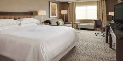 Spacious king suite with TV, business desk, and lounge area at Wyndham Omaha.
