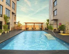 stunning outdoor pool with seating area at Hilton Garden Inn Trivandrum.