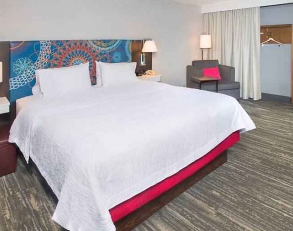 colorful king bedroom with natural light and work desk ideal for working remotely at Hampton Inn & Suites Annapolis.