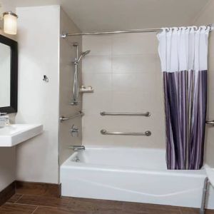 Guest bathroom with shower and tub at La Quinta Inn & Suites By Wyndham New York City Central Park.