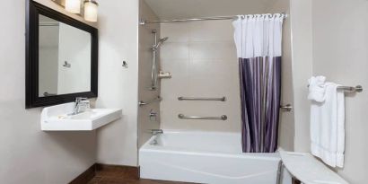 Guest bathroom with shower and tub at La Quinta Inn & Suites By Wyndham New York City Central Park.