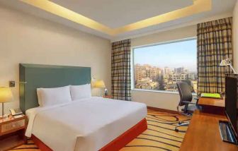 Bright hotel room with desk at the DoubleTree by Hilton Hotel Gurgaon - New Delhi NCR.