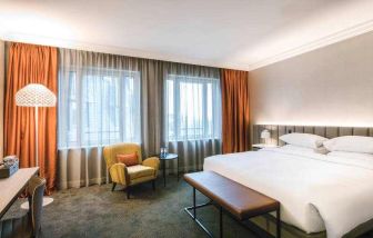 King bedroom with working station at the Hilton Brussels Grand Place .