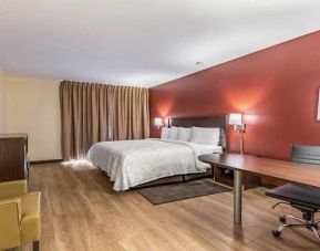 Luxurious king suite with business desk and TV at Red Roof PLUS+ & Suites Houston - IAH Airport SW.