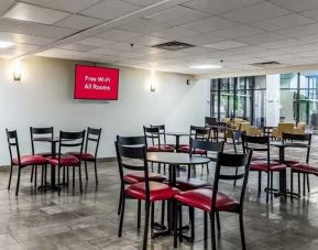 Open-plan dining and coworking space at Red Roof PLUS+ & Suites Houston - IAH Airport SW.