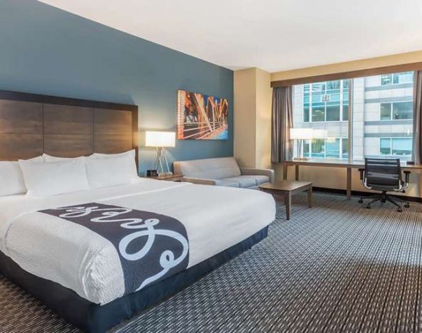 King bedroom with desk and sofa at La Quinta Inn & Suites By Wyndham Chicago Downtown.