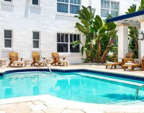 Outdoor pool with lounges at Blue Moon Hotel.