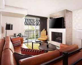 Beautiful hotel suite with sofa, fireplace and TV screen at Le Montrose.