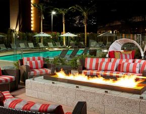 Beautiful outdoor patio by the pool with firepit at Residence Inn By Marriott LAX Airport.