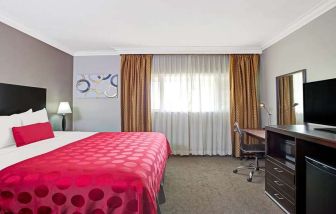King bedroom with desk at Ramada Los Angeles Downtown West.
