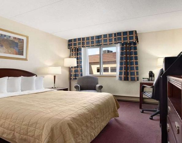 Hotel bedroom with TV screen and desk at Travelodge Ottawa East.