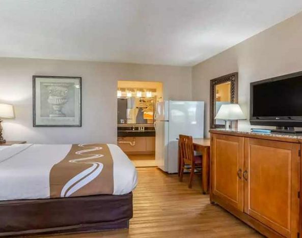Spacious delux king room with TV, business desk, and fridge at Quality Inn Pasadena.