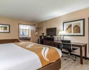 King bedroom with business desk and TV at Quality Inn Pasadena.