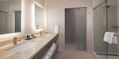 Guest bathroom with shower at H Hotel Los Angeles, Curio Collection By Hilton.
