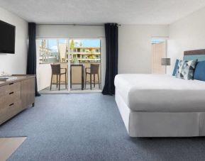 Spacious delux king with TV, balcony, and lots of natural light at Pacific Edge Hotel.