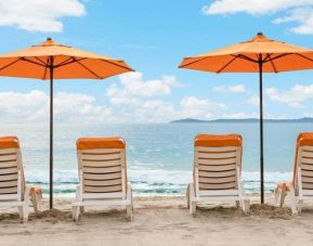 Enjoy a beach chair and beach umbrella on the beach at Pacific Edge Hotel.