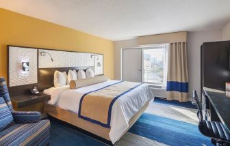 Spacious king room with work desk, couch, TV, and natural light at Southbank Hotel Jacksonville Riverwalk.