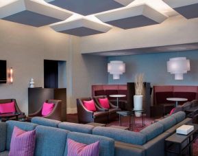 Comfortable couches in open-plan setting ideal for coworking at Courtyard By Marriott New York JFK Airport.