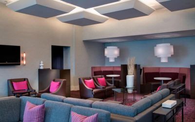 Comfortable couches in open-plan setting ideal for coworking at Courtyard By Marriott New York JFK Airport.