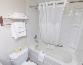 Clean guest bathroom with shower and bath combo at West Wing Hotel At Park Town.