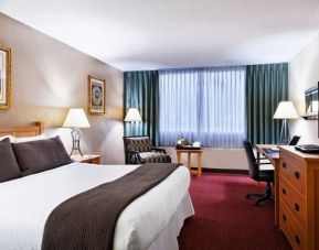 Spacious king suite with TV, business desk, and couch at Millennium Maxwell House Hotel Nashville.