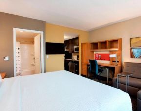 Lovely king bedroom with business desk, TV, and lounge area at TownePlace Suites Orlando at FLAMINGO CROSSINGS.