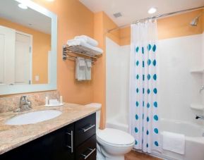 Spacious guest bathroom with shower and bath at TownePlace Suites Orlando at FLAMINGO CROSSINGS.