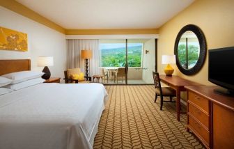 Luxurious king room with TV, terrace, work desk and lots of natural light at Outrigger Kona Resort And Spa.