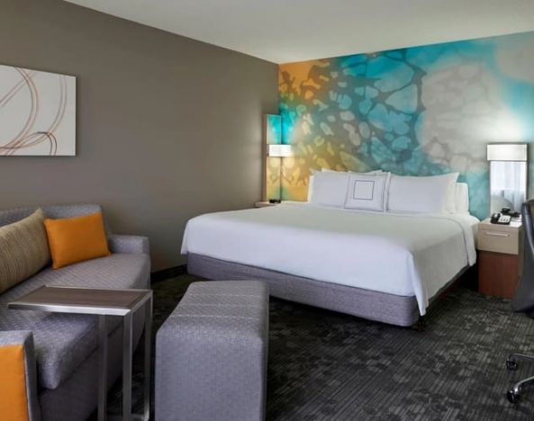 Delux king room with couch and business desk at Courtyard By Marriott Toronto Airport.