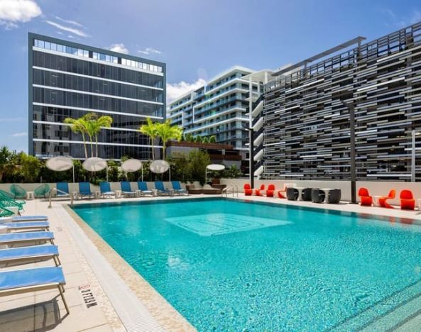 Stunning outdoor pool with sunbeds and seating area at Aloft Miami Aventura.