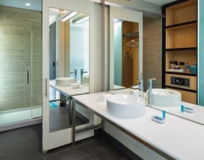 Spacious guest bathroom with shower at Aloft Miami Aventura.