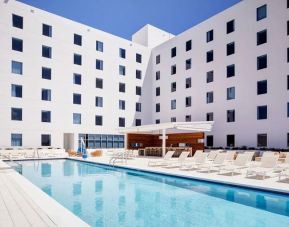 Stunning outdoor pool with sunbeds at AC Hotel by Marriott Miami Aventura.