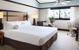 Comfortable king bedroom with couch and work station at The Ambrose Hotel Santa Monica.