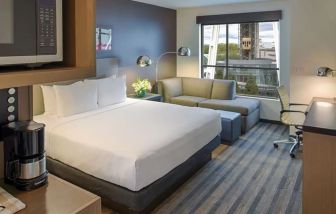 Comfortable king suite with business desk, TV, coffee machine, and lounge at Hyatt House Seattle Downtown.