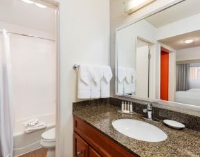 Private guest bathroom with shower and bath at Clementine Hotel & Suites Anaheim.