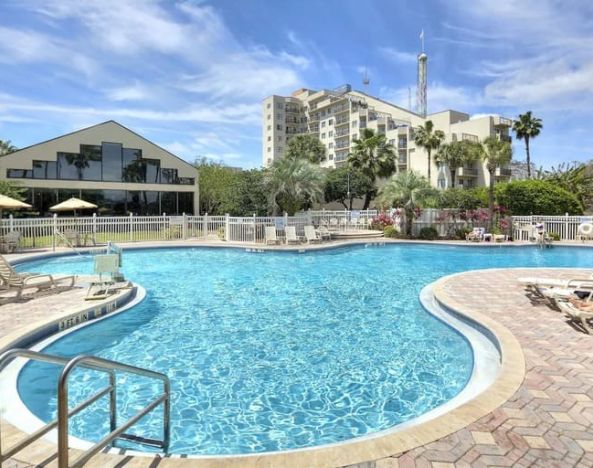 Stunning outdoor pool with sun beds at Enclave Suites by Sky Hotels & Resorts.