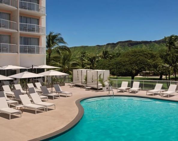 Stunning outdoor pool with sunbeds and cabanas at Park Shore Waikiki.