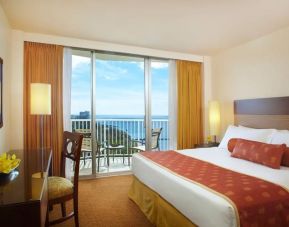 Spacious king bedroom with sea view, balcony, and business desk at Park Shore Waikiki.