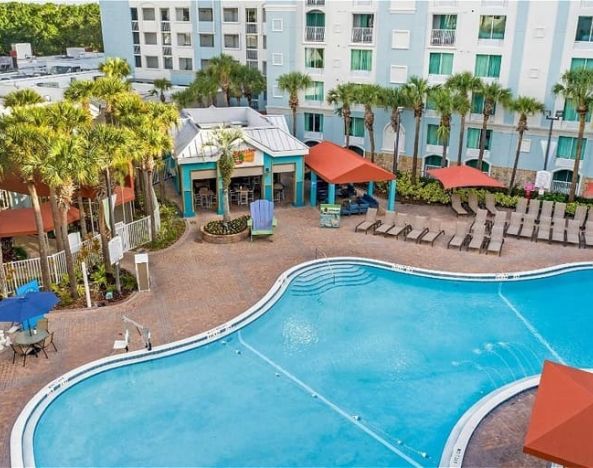 Stunning outdoor pool with sunbeds and umbrellas at Holiday Inn Resort Lake Buena Vista.