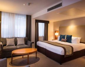 Wide view of the Thistle Trafalgar Square executive king room, featuring large bed, sofa, and TV.