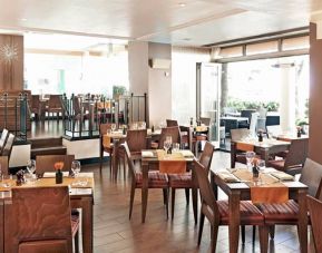 Indoor seating with tables for two or four diners, with large windows and a window floor.